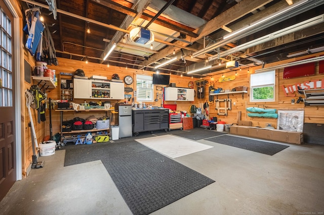 185 Lovers Ln, Fairfield, CT 06824 - garage featuring a workshop area, wooden walls, a garage door opener, and freestanding refrigerator