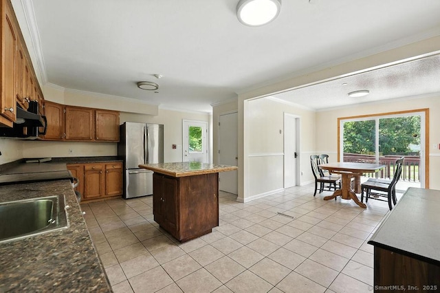 26 Paula Rd, East Haddam, CT 06423 - kitchen with freestanding refrigerator, a kitchen island, crown molding, light tile patterned floors, and dark countertops