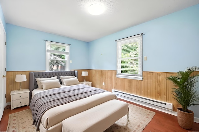 26 Paula Rd, East Haddam, CT 06423 - bedroom featuring baseboard heating, wainscoting, wood walls, and wood finished floors