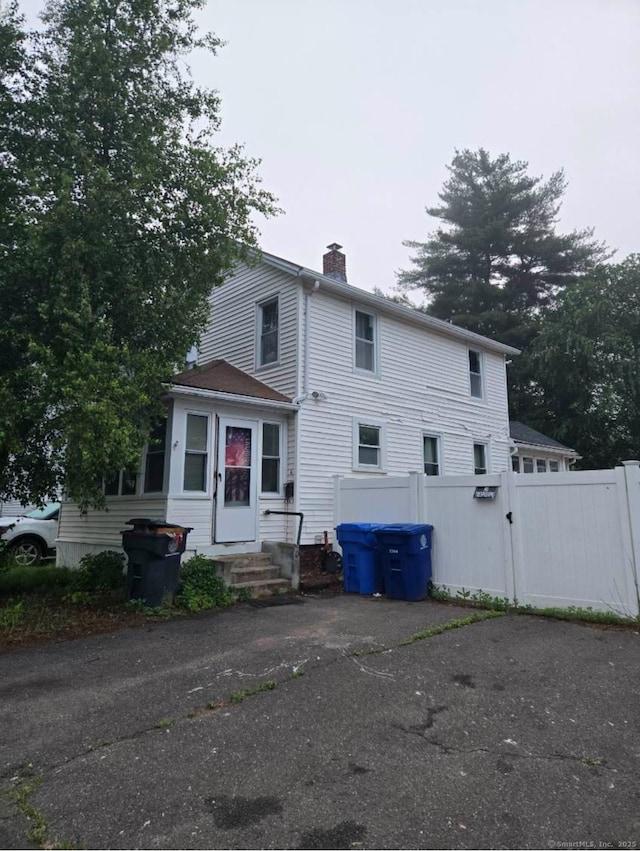 6 Cedar St, Enfield, CT 06082 - view of front facade featuring a chimney, entry steps, and a gate