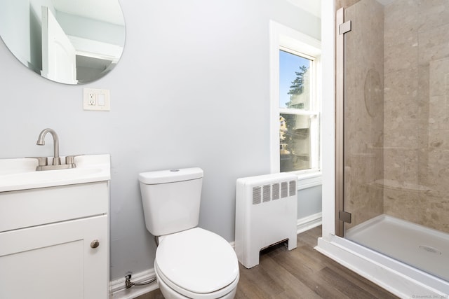 57 Wilson St, New Britain, CT 06051 - bathroom with radiator, vanity, toilet, a tile shower, and wood finished floors