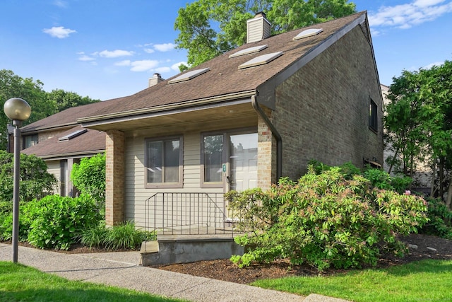 2437 Bedford St Unit E5, Stamford, CT 06905 - view of home's exterior with a chimney, brick siding, and a shingled roof