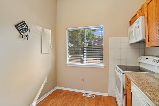 2437 Bedford St Unit E5, Stamford, CT 06905 - kitchen featuring white appliances, light wood-style flooring, baseboards, light countertops, and brown cabinets