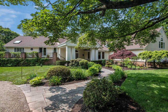15 NE Rd, Farmington, CT 06032 - view of front facade with a front yard, brick siding, and roof with shingles