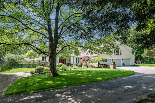 15 NE Rd, Farmington, CT 06032 - view of property hidden behind natural elements with a garage, a front yard, and concrete driveway
