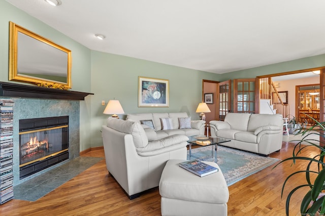 101 Overton Farm Dr, Southbury, CT 06488 - living room with wood finished floors, a tiled fireplace, and stairs
