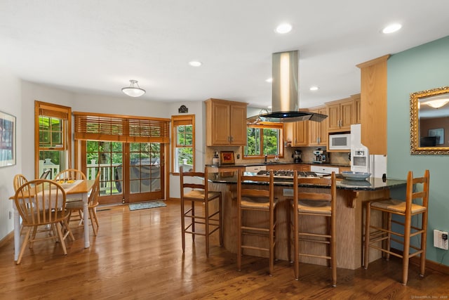 101 Overton Farm Dr, Southbury, CT 06488 - kitchen with island exhaust hood, white appliances, wood finished floors, recessed lighting, and a breakfast bar area