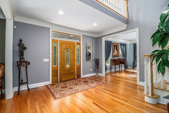 entrance foyer featuring ornamental molding, wood finished floors, baseboards, healthy amount of natural light, and recessed lighting