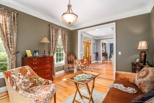 living area featuring ornamental molding, wood finished floors, and baseboards