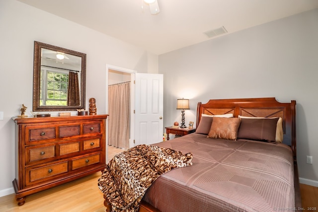 bedroom with light wood-type flooring and baseboards