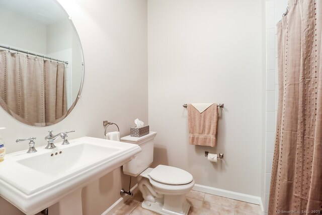 full bathroom with toilet, tile patterned flooring, baseboards, a sink, and curtained shower