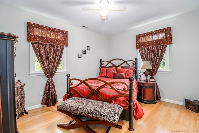bedroom featuring multiple windows, wood finished floors, and baseboards
