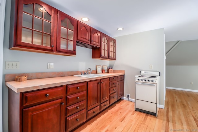 kitchen with white electric range, a sink, light wood-style floors, glass insert cabinets, and light countertops