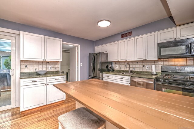 39 Jackson Dr Unit 39, Milford, CT 06460 - kitchen with black appliances, a sink, white cabinets, and backsplash