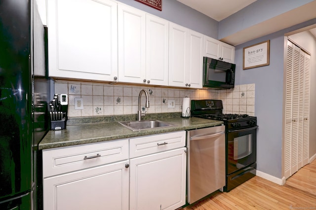 39 Jackson Dr Unit 39, Milford, CT 06460 - kitchen with black appliances, a sink, dark countertops, light wood-style floors, and white cabinetry