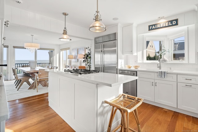 685 Fairfield Beach Rd Unit 685, Fairfield, CT 06824 - kitchen with stainless steel appliances, a center island, light wood finished floors, and light countertops