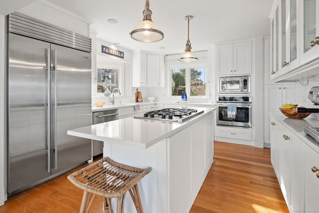 685 Fairfield Beach Rd Unit 685, Fairfield, CT 06824 - kitchen featuring built in appliances, white cabinets, a kitchen bar, and a center island