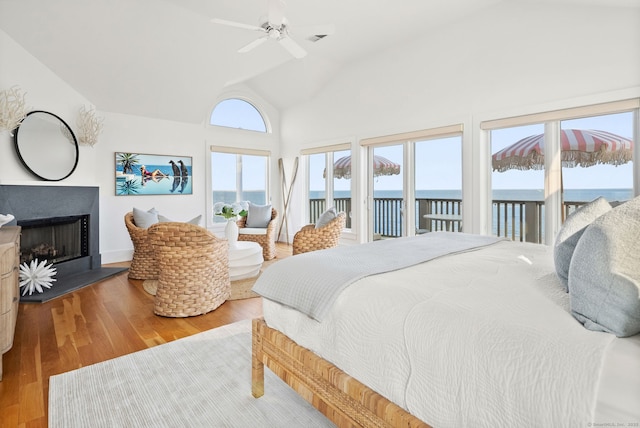 685 Fairfield Beach Rd Unit 685, Fairfield, CT 06824 - bedroom featuring access to exterior, vaulted ceiling, wood finished floors, a water view, and a fireplace with raised hearth