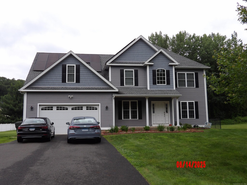 1705 Orchard Rd, Berlin, CT 06037 - view of front of home featuring driveway, a front yard, solar panels, and covered porch