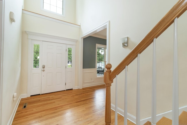 1705 Orchard Rd, Berlin, CT 06037 - entryway featuring healthy amount of natural light, stairway, light wood finished floors, a high ceiling, and a wainscoted wall
