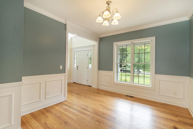 1705 Orchard Rd, Berlin, CT 06037 - empty room with a chandelier, crown molding, a wainscoted wall, light wood-style floors, and a decorative wall