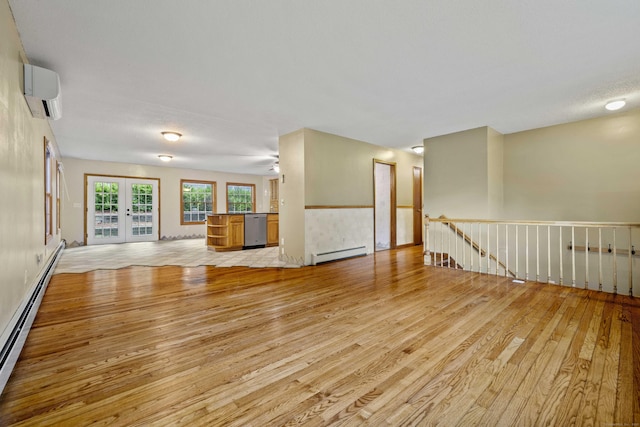 9 Philip Ln, Ledyard, CT 06339 - unfurnished living room featuring light wood-style floors, a baseboard radiator, a wall mounted AC, and french doors