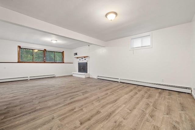 9 Philip Ln, Ledyard, CT 06339 - unfurnished living room featuring baseboard heating, a brick fireplace, and light wood-type flooring