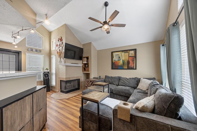 136 Carriage Crossing Ln Unit 136, Middletown, CT 06457 - living room with a ceiling fan, a textured ceiling, light wood finished floors, a tile fireplace, and lofted ceiling