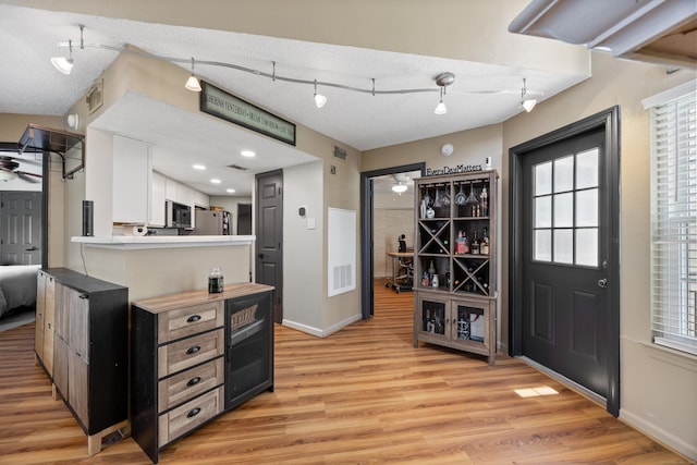 136 Carriage Crossing Ln Unit 136, Middletown, CT 06457 - kitchen featuring light wood-type flooring, stainless steel appliances, a textured ceiling, light countertops, and white cabinetry