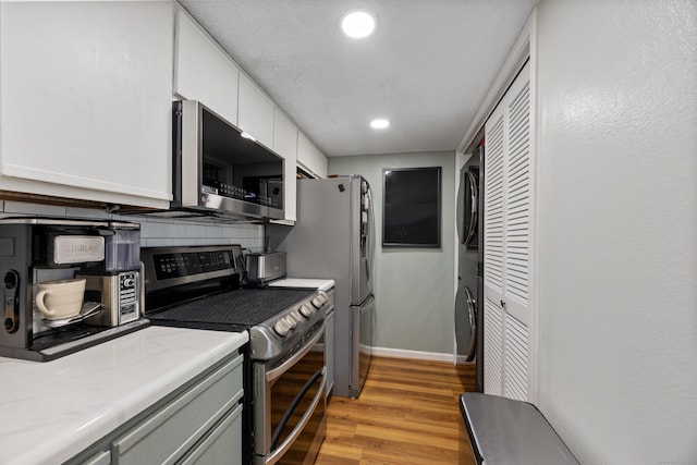 136 Carriage Crossing Ln Unit 136, Middletown, CT 06457 - kitchen with stainless steel appliances, estacked washer and dryer, backsplash, light wood-style flooring, and recessed lighting