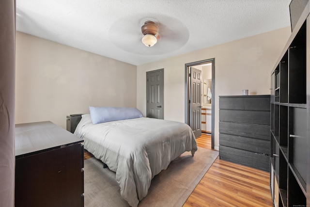 136 Carriage Crossing Ln Unit 136, Middletown, CT 06457 - bedroom with light wood-style floors, a ceiling fan, connected bathroom, and a textured ceiling