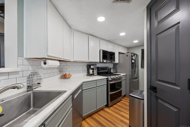 136 Carriage Crossing Ln Unit 136, Middletown, CT 06457 - kitchen with appliances with stainless steel finishes, light wood-type flooring, tasteful backsplash, white cabinetry, and light countertops