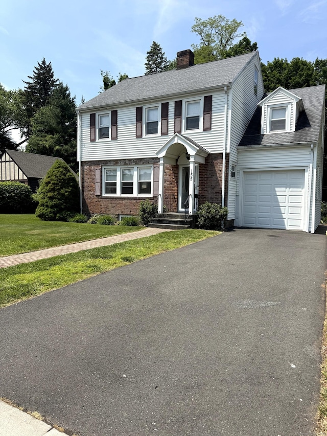 155 Harding St, New Britain, CT 06052 - colonial-style house with a garage, a chimney, asphalt driveway, roof with shingles, and brick siding