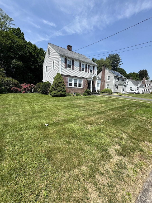155 Harding St, New Britain, CT 06052 - view of front of house featuring a chimney, a front lawn, and brick siding