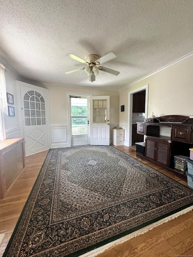 155 Harding St, New Britain, CT 06052 - living area featuring a decorative wall, crown molding, wood finished floors, ceiling fan, and a textured ceiling