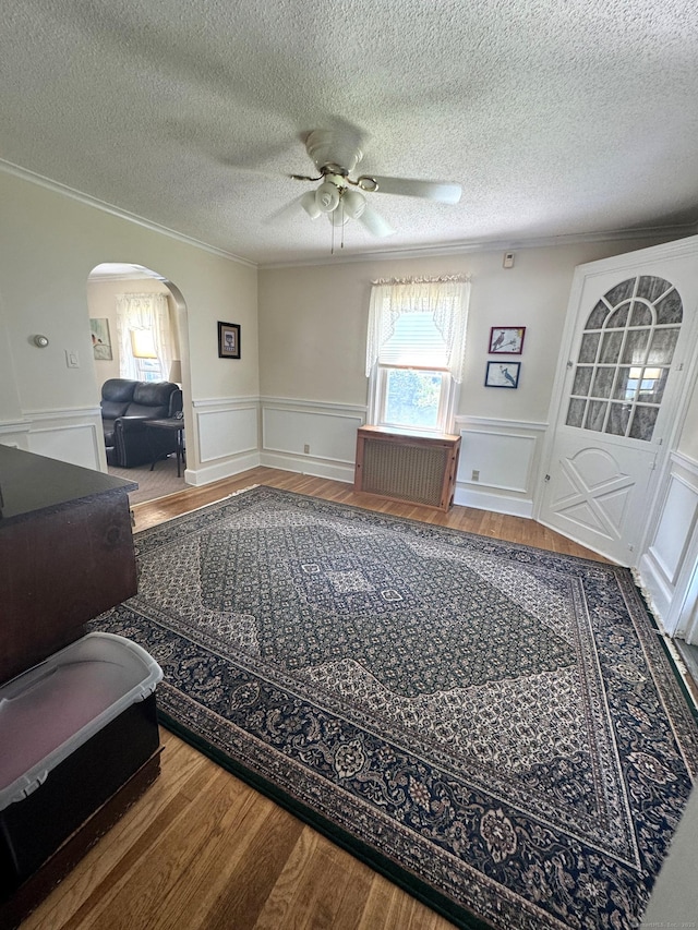 155 Harding St, New Britain, CT 06052 - living area featuring arched walkways, ceiling fan, plenty of natural light, ornamental molding, and wainscoting