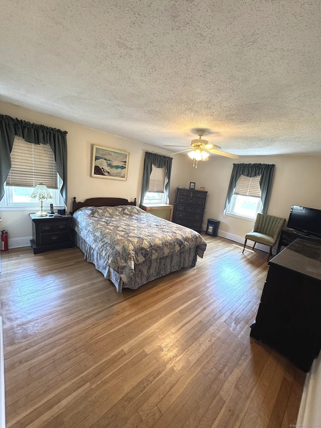 155 Harding St, New Britain, CT 06052 - bedroom with multiple windows, hardwood / wood-style flooring, a textured ceiling, and a ceiling fan
