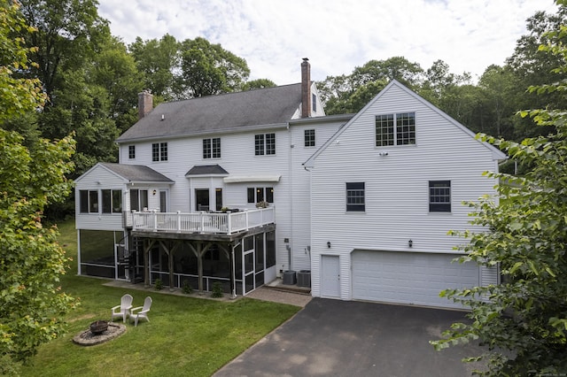 109 Andrew Dr, Canton, CT 06019 - rear view of property featuring a sunroom, a chimney, an attached garage, and asphalt driveway
