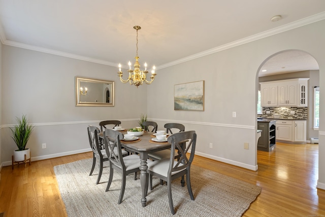 109 Andrew Dr, Canton, CT 06019 - dining space featuring light wood-style floors, arched walkways, a chandelier, and ornamental molding