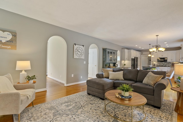 109 Andrew Dr, Canton, CT 06019 - living room featuring arched walkways, light wood finished floors, a chandelier, and recessed lighting