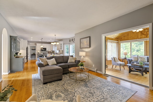 109 Andrew Dr, Canton, CT 06019 - living area with a chandelier, a baseboard heating unit, light wood-style floors, and arched walkways