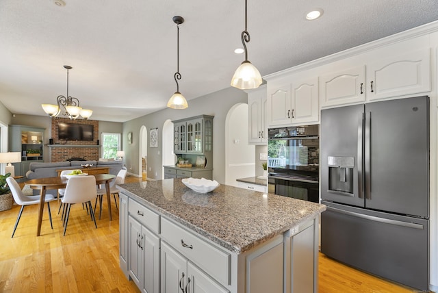 109 Andrew Dr, Canton, CT 06019 - kitchen featuring stainless steel fridge with ice dispenser, arched walkways, a kitchen island, open floor plan, and decorative light fixtures
