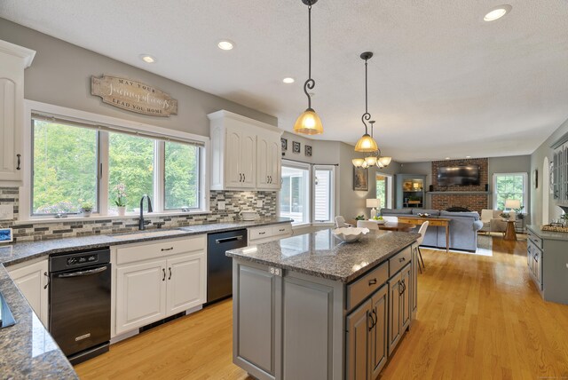 109 Andrew Dr, Canton, CT 06019 - kitchen with dishwasher, tasteful backsplash, a fireplace, light wood-style flooring, and white cabinets