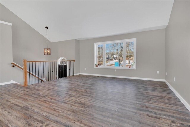 110 Willowbrook Rd, Cromwell, CT 06416 - unfurnished living room with vaulted ceiling, a chandelier, wood finished floors, and baseboards