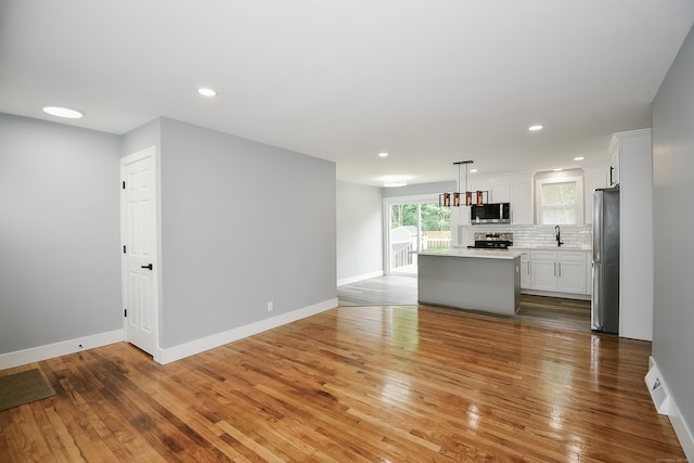 10 Yale Dr, Enfield, CT 06082 - unfurnished living room featuring a sink, light wood finished floors, baseboards, and recessed lighting
