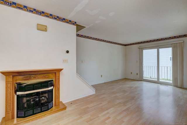 269 Captain Thomas Blvd Unit 12, West Haven, CT 06516 - unfurnished living room featuring wood finished floors, a fireplace with raised hearth, and baseboards
