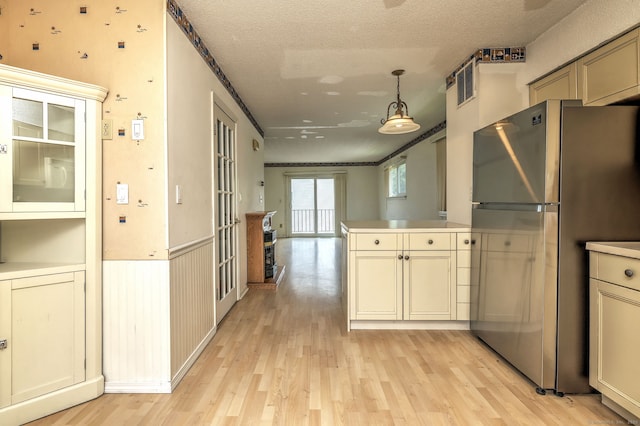 269 Captain Thomas Blvd Unit 12, West Haven, CT 06516 - kitchen with freestanding refrigerator, light wood-type flooring, a peninsula, pendant lighting, and a textured ceiling