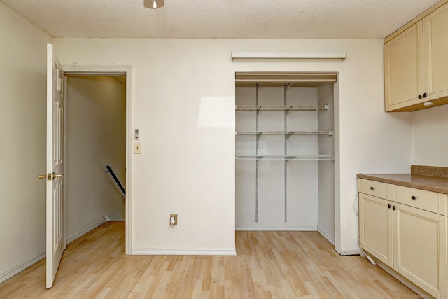 269 Captain Thomas Blvd Unit 12, West Haven, CT 06516 - kitchen with light wood finished floors, cream cabinetry, and baseboards