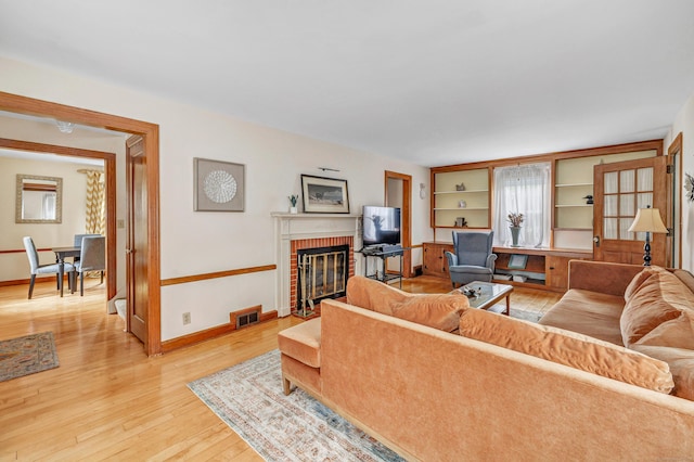 40 Cutspring Rd, Stratford, CT 06614 - living room with light wood-type flooring and a brick fireplace