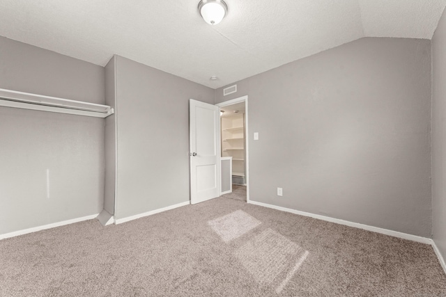 101 Cannon Rd, East Hartford, CT 06108 - unfurnished bedroom with carpet, baseboards, vaulted ceiling, a closet, and a textured ceiling